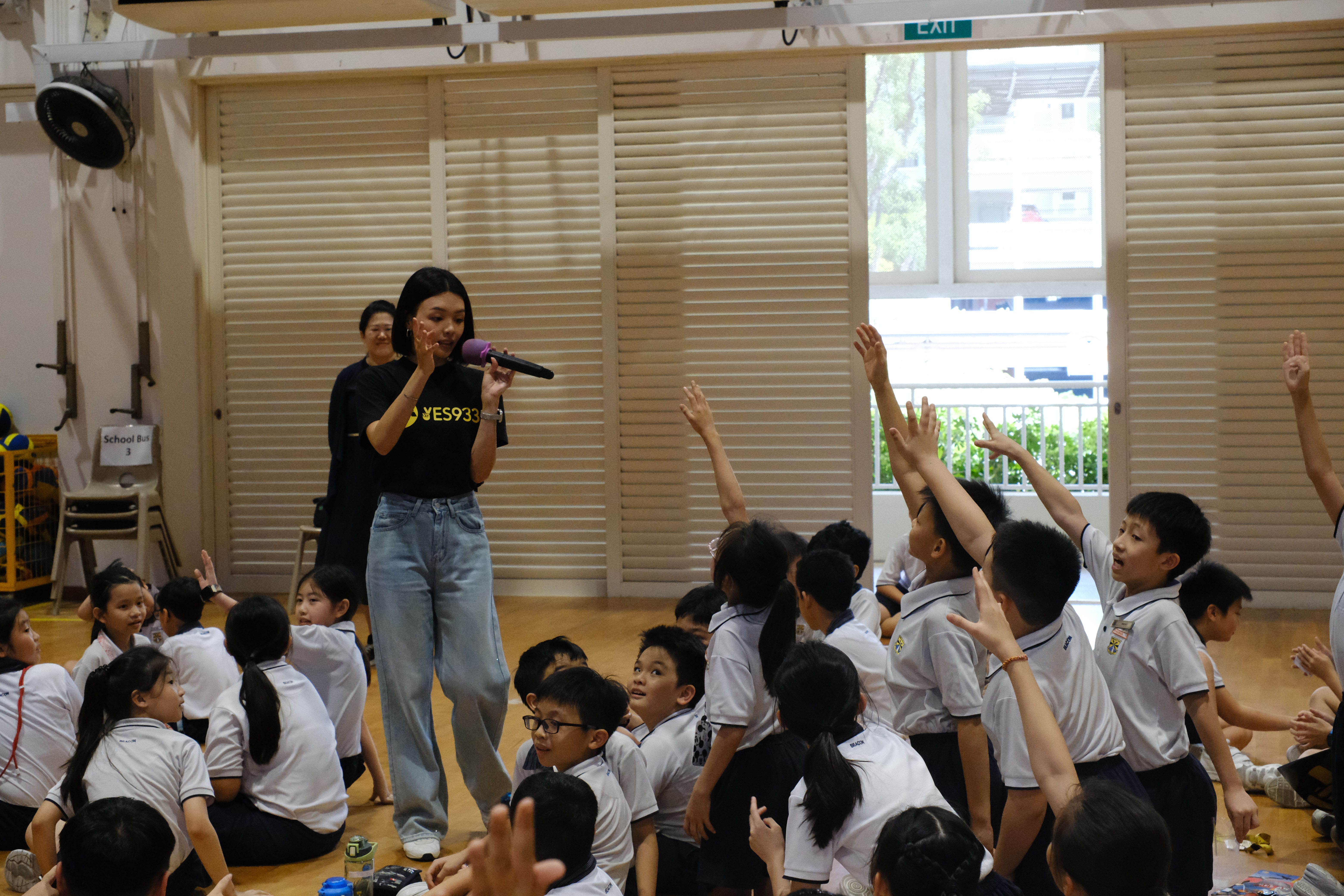 Students eagerly raised their hands to participate in the exciting YES 933 interactive session.